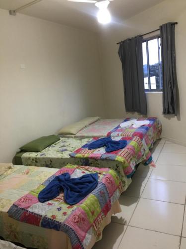 迈里波朗Pousada Oluap的客房内的两张床,配有衣服