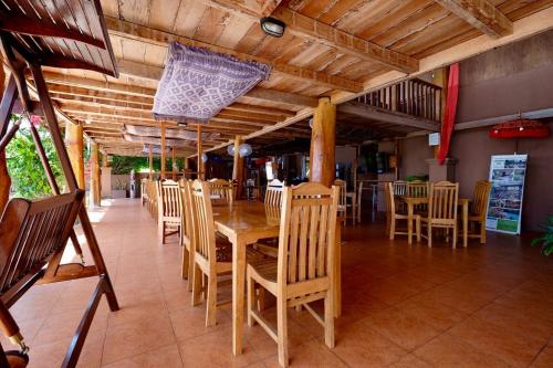 WeetebulaMario Hotel and Cafe的一间带木桌和椅子的用餐室