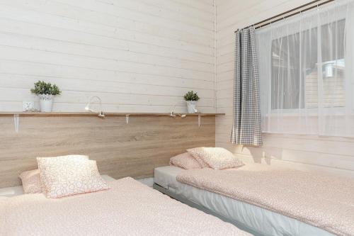 波别罗沃Domki "Arkadia"的配有2张床的带窗户和白色墙壁的客房