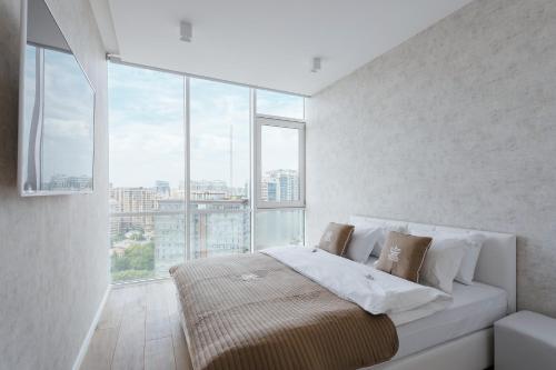 敖德萨皇家公寓的一间卧室设有一张大床和大窗户