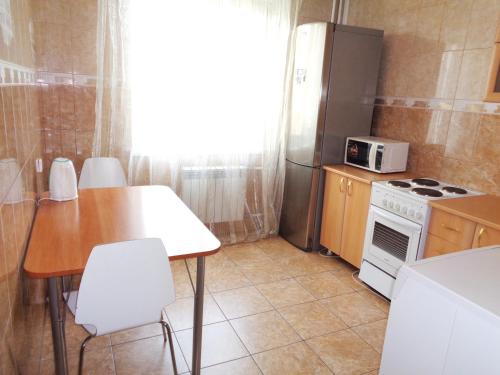 克拉斯诺亚尔斯克Apartments Baturina 20 (2 etag)的厨房配有桌子、炉灶和冰箱。
