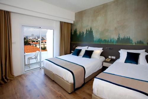 利马索尔佩弗克斯城市酒店的酒店客房设有两张床和一个阳台。