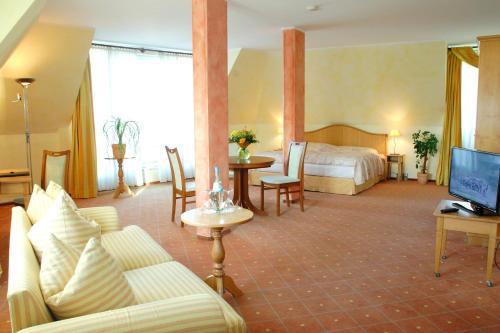 莱比锡坎帕尼尔莱比锡酒店的酒店客房,配有床和沙发