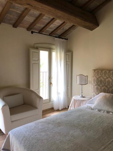 拉文纳Le Case Di San Vitale Easy的卧室配有床、椅子和窗户。