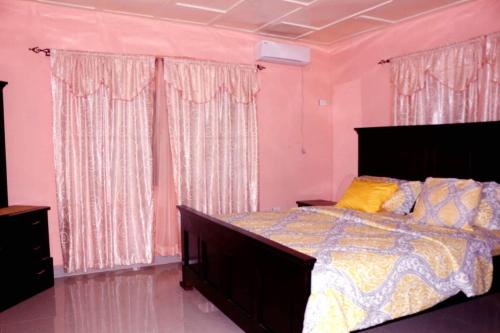NatrinaMontgomery Brother Estate的卧室配有一张带粉红色墙壁的大床