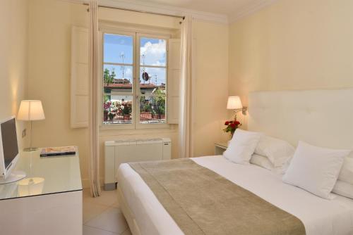 佛罗伦萨佛罗伦萨酒店的白色的卧室设有床和窗户
