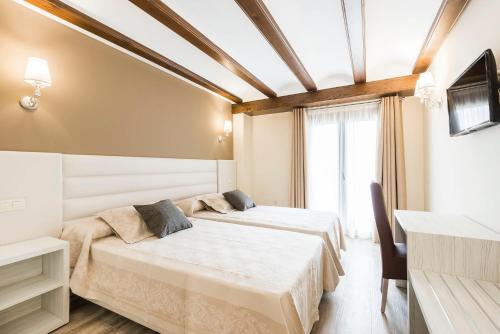 阿尔巴拉辛Hotel Atiana的酒店客房设有两张床和电视。
