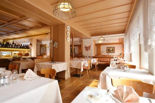 莫埃纳Hotel La Soldanella的一间餐厅,房间内设有白色的桌椅