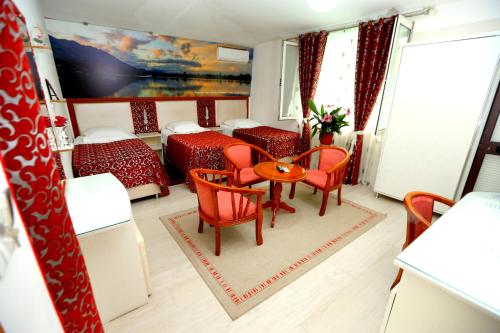 斯库台卡杜库酒店的一间设有两张床和一张桌子及椅子的房间