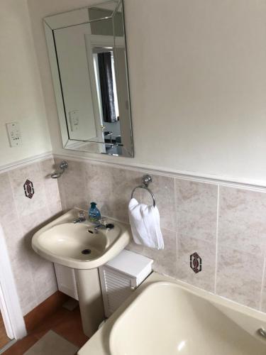 DysartDysart Sea View Apartment的浴室配有盥洗盆、镜子和浴缸
