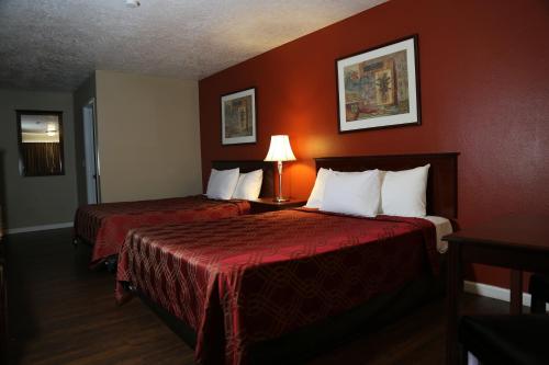 凯尔索Americas Best Value Inn Kelso的酒店客房,设有两张带红色墙壁的床