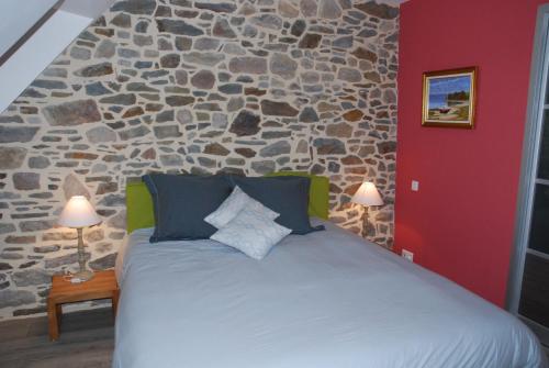 蒙特多尔E-Harz Ar Menez的一间卧室设有一张带石墙的大床