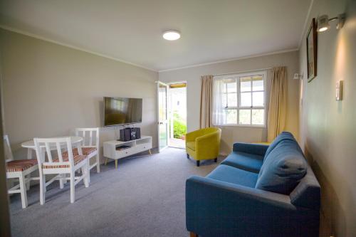 陶波Phoenix Thermal Resort - Taupo的客厅配有蓝色的沙发和桌子