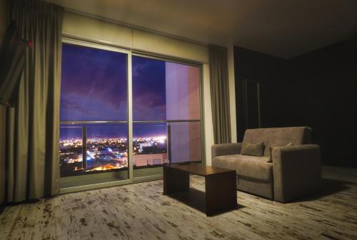 圣克鲁斯Urban Suites Apart Hotel的客房设有椅子和享有城市景观的窗户。