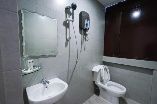 乔治市Grand FC Hotel的一间带水槽、卫生间和镜子的浴室
