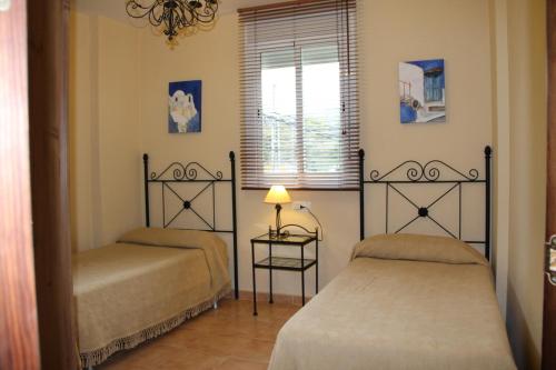 贝瑙汉Casa Estacion de Benaojan的一间卧室设有两张床和窗户。