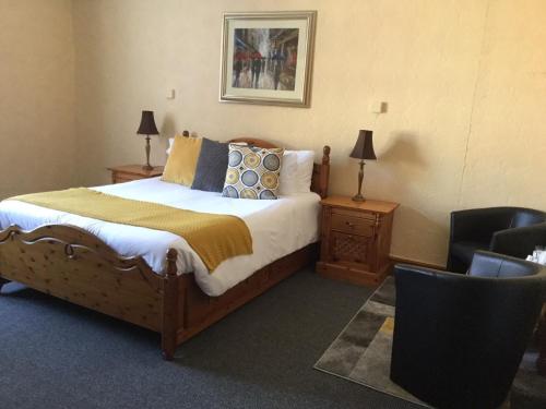 利物浦Woodlands Guest House的一间卧室配有一张大床和一把椅子