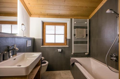 格英Koasa Chalet的浴室配有白色浴缸和水槽