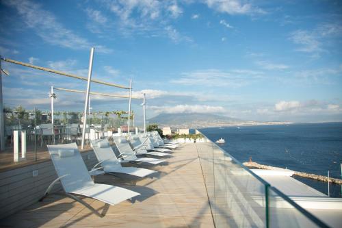 那不勒斯维苏威大酒店的俯瞰大海的阳台上一排白色椅子