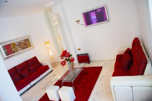 马尔托斯Hotel Fernando IV的客厅配有两张红色的沙发和一张桌子