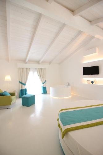 特罗佩阿Il Borghetto Creative Resort的白色卧室设有一张大床和一个浴缸