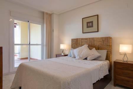 贝纳尔马德纳Relax Frente al Mar的卧室配有一张白色大床和两盏灯。