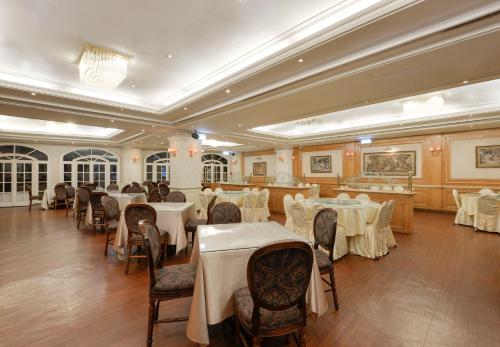 台中市富比世大饭店的用餐室配有桌椅和白色桌布