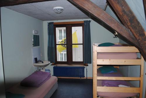 布鲁日查理罗肯特青年旅馆的一间卧室设有两张双层床和一扇窗户。