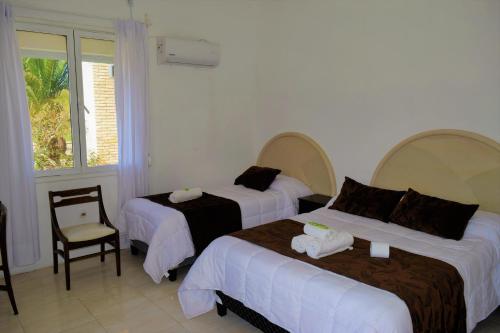 拉帕洛马Hotel Cabo Santa Maria的酒店客房,配有两张床和椅子