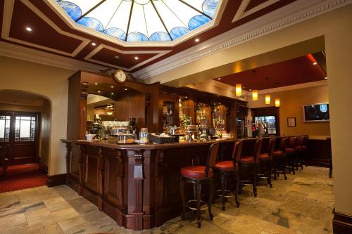 巴利米纳阿代尔阿尔姆斯酒店的餐厅内的酒吧,拥有彩色玻璃天花板