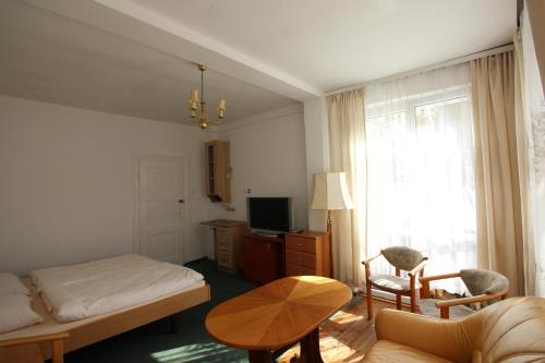 米兹多洛杰Dom wypoczynkowy Szarotka&Krokus的一间卧室配有一张床、一张桌子和一个窗户。