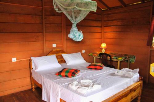 锡吉里亚Sigiri Royal Point Tree House的木制客房内的一间卧室,配有一张床