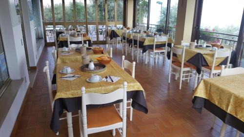 布雷佐内加尔达Hotel Residence Panoramica的用餐室配有带黄色和黑色桌布的桌子