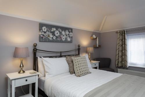 戈斯波特Brockhurst Lodge的一间卧室设有床、两张桌子和一扇窗户