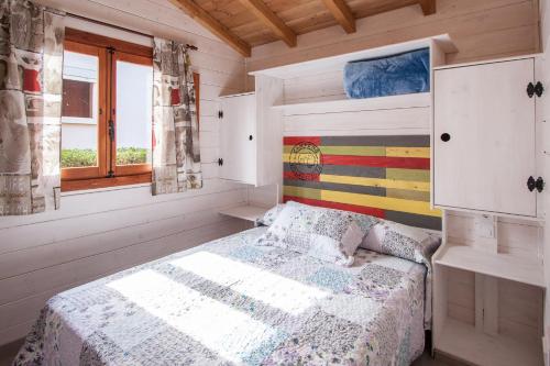 La Rasa SelorioCamping Villaviciosa的木制客房内的一间卧室,配有一张床