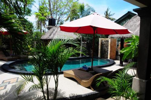 吉利特拉旺安吉利福拉什协和酒店的游泳池配有红色遮阳伞、椅子、桌子和遮阳伞