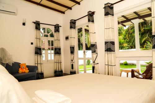 尼甘布尼甘布安氏别墅的一间卧室配有一张床、一张沙发和窗户。