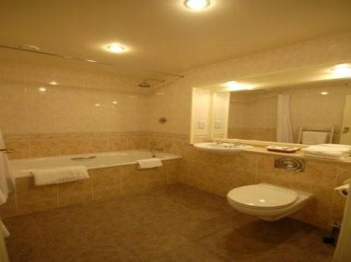 BaintonWolds Village Hotel的带浴缸、卫生间和盥洗盆的浴室