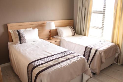 德班维尔DCS Accommodation Cape Gate的带窗户的客房内的两张床