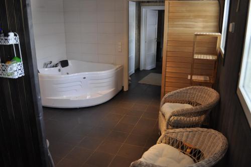 Kannuskoski图汉能陶瑞纳塔洛酒店的一间带浴缸和2把藤椅的浴室