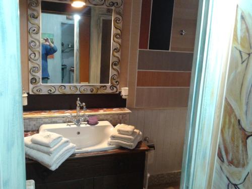 Castel LagopesoleLa Casetta Di Anna的浴室配有盥洗盆、镜子和毛巾