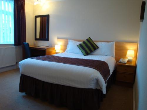 费勒姆旅程法尔汉姆索伦特度假酒店的酒店客房设有一张大床和两盏灯。