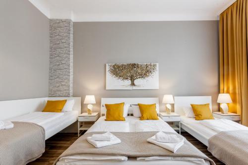 柏林Dilo Apartments - MyGold Apartment 120 SQM的客厅配有两张床和黄色枕头