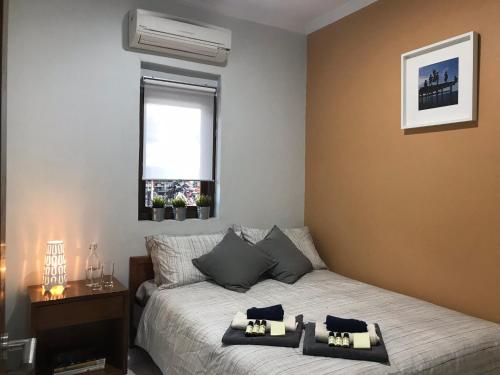 卡里蒙贾瓦凯西广场旅馆的一间卧室设有一张床和一个窗口