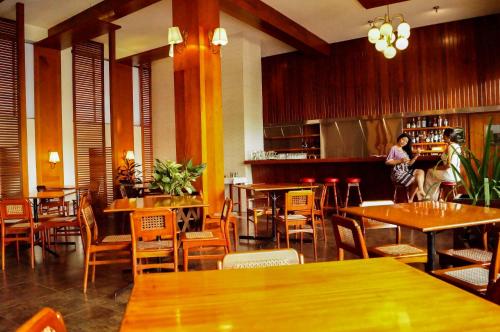 普卡尔帕奔驰大酒店的一间带木桌椅的餐厅和一间酒吧