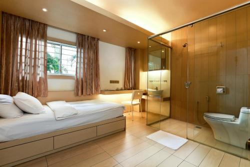 哥打巴鲁古宝大旅店的一间卧室设有一张床、淋浴和卫生间