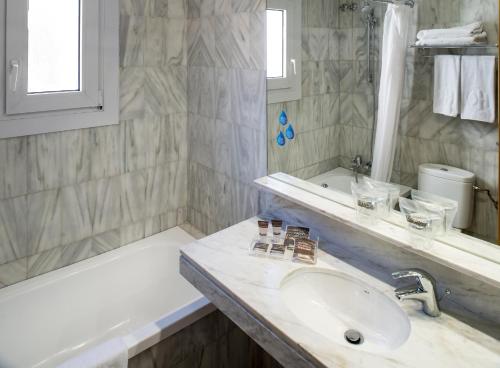 巴塞罗那加泰罗尼亚卡斯特诺酒店的白色的浴室设有水槽和浴缸。