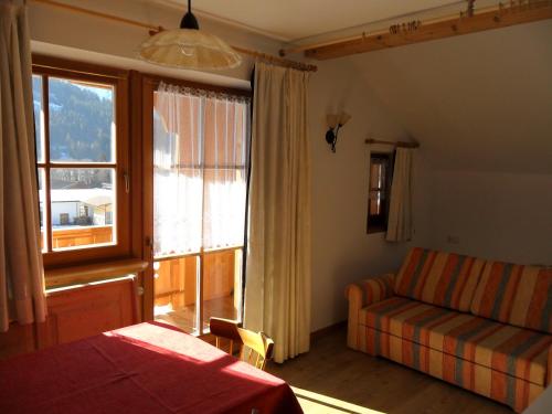 维拉巴萨Appartamenti Stauderhof的一间卧室设有床、窗户和沙发