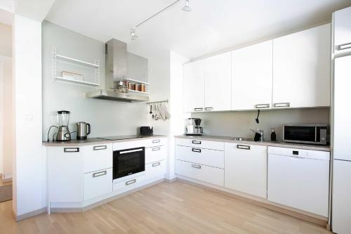 纳坦利Design Apartments Kristiina的白色的厨房配有白色橱柜和木地板