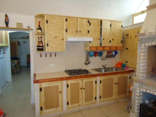 马蒂诺Bilocale a 15km da Gallipoli的一个带木制橱柜和水槽的厨房